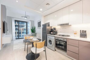 Enjoy a compact living space with a kitchenette, dining area, and large window offering a view of the outside.