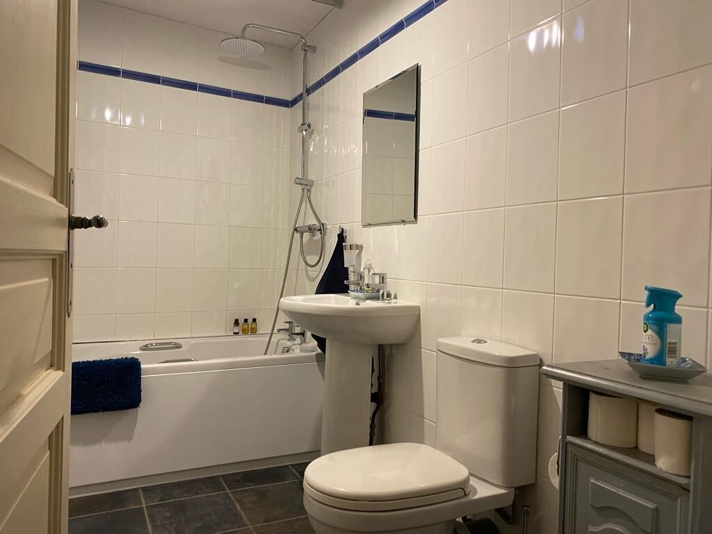 Ein Badezimmer mit Badewanne, Toilette, Waschbecken und Spiegel.