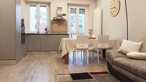 Une cuisine moderne avec un coin repas, un canapé et une horloge au mur.