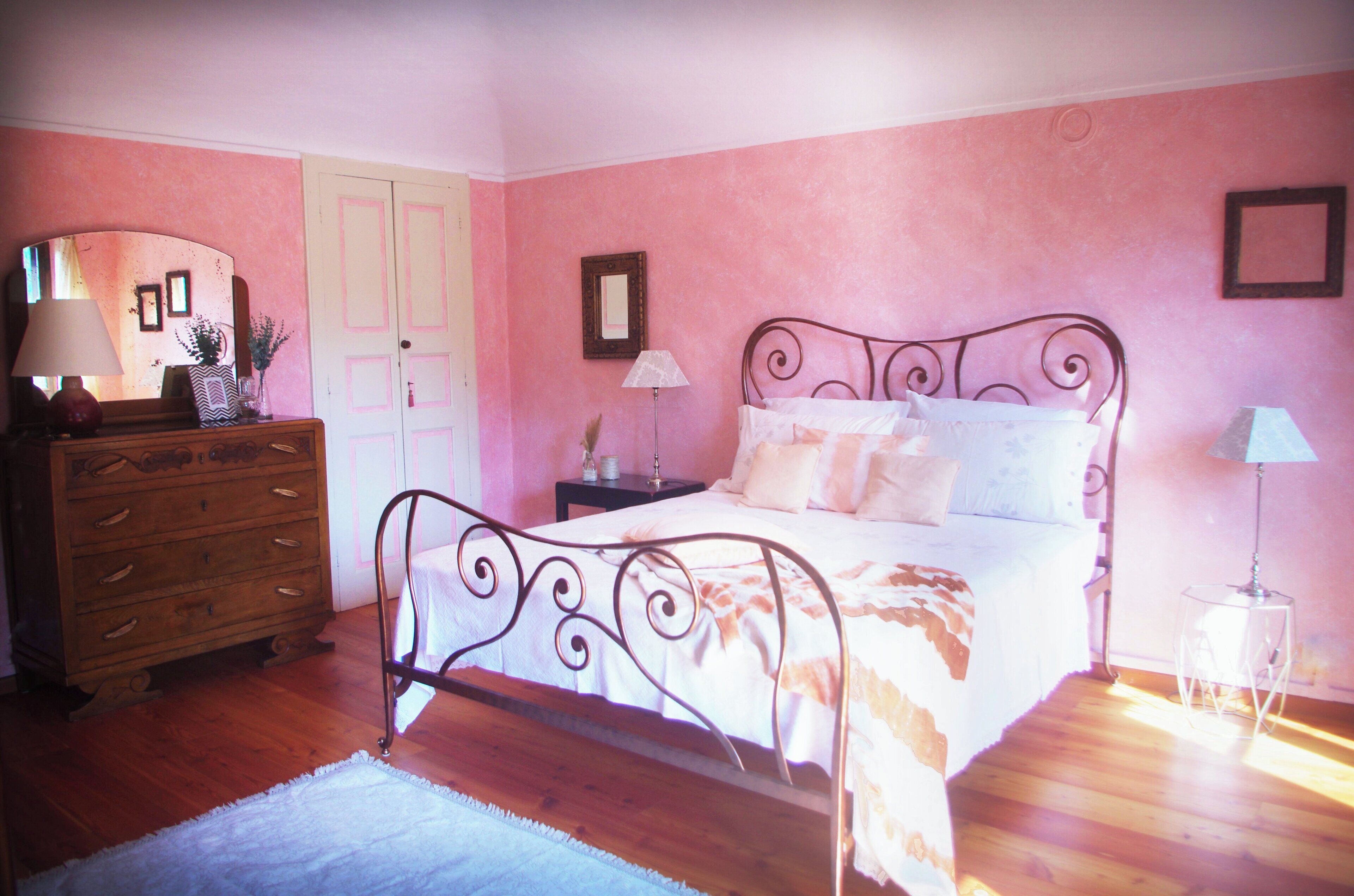 Una camera da letto con un letto, una cassettiera, comodini e una porta.