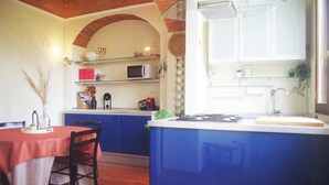 Une cuisine avec des meubles bleus, un four à micro-ondes et un évier.