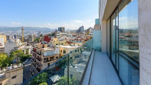 Un edificio alto con un balcón de cristal que ofrece vistas panorámicas de la ciudad.