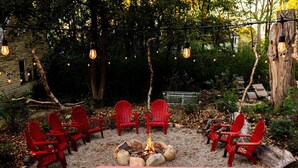Un foyer entouré de chaises rouges et d’une table rose, le tout aménagé dans un jardin.