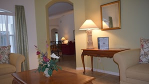 A living room with a wooden coffee table, two sofas, a lamp, and a framed certificate on a side table.