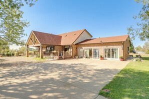 Een huis met twee verdiepingen, een bakstenen gevel, een overdekte veranda en een garage.