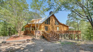 Eine Holzhütte mit einer Holzterrasse und einer Treppe zum Eingang.