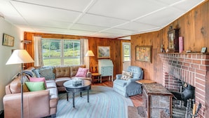 Un salon chaleureux avec une cheminée, des canapés en cuir et un décor intérieur en bois.