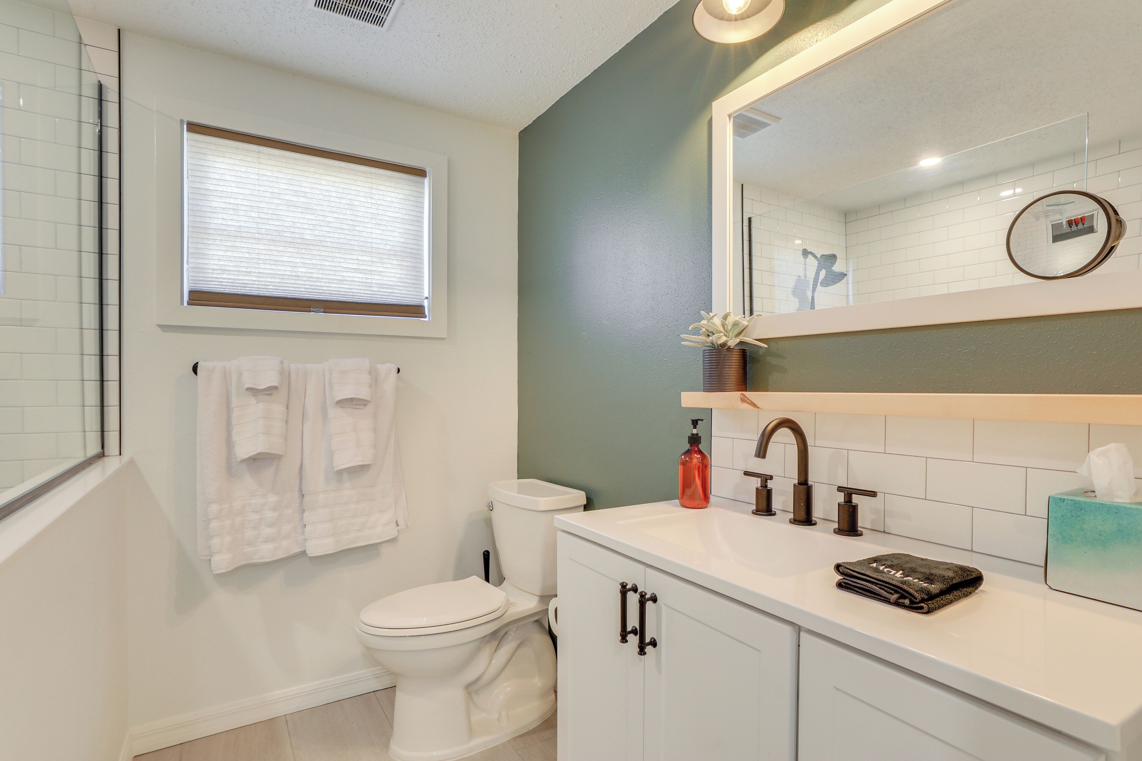 A modern bathroom with a toilet, sink, and mirror.