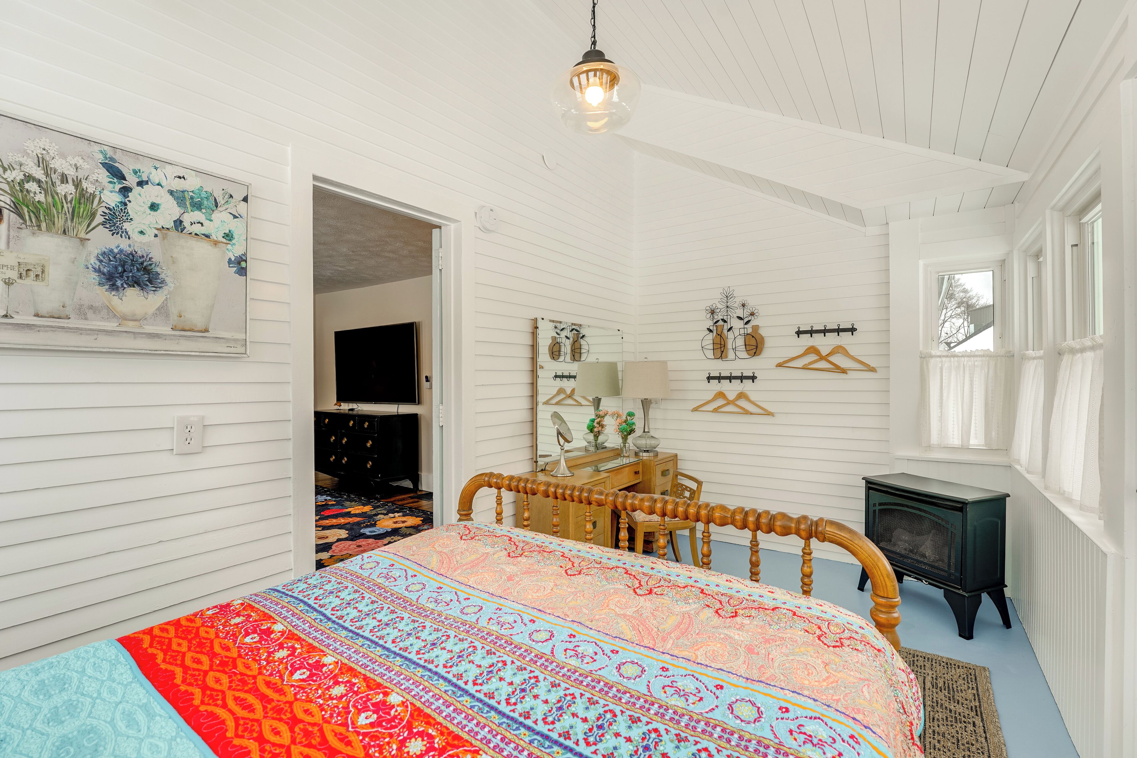 A bedroom with a wooden bed, a dresser, a mirror, and a radiator.