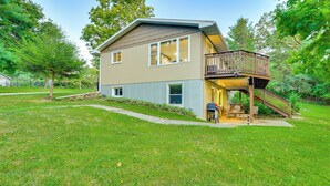 A two-story house with a balcony and a covered outdoor seating area. - Okee Bay House on Lake Wisconsin w/ Private Dock! (Lodi)