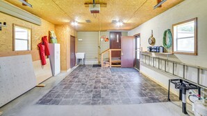 A spacious room with a high ceiling, tiled floor, and a wooden interior. - Yale Home in the Heart of Pheasant Hunting Country (Yale)
