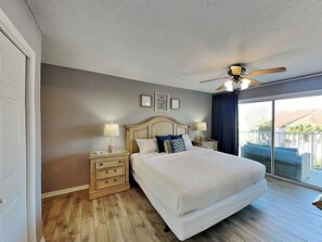 A bedroom with a large bed, two bedside tables with lamps, a ceiling fan, and a view of the outside. - Maravilla #1306 | Pet Friendly, Near Beach + Resort Amenities (Miramar Beach)
