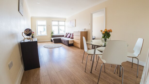 Una sala de estar moderna con comedor, un sofá, una mesa de centro y un ventanal grande.