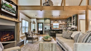 A cozy cabin interior with a fireplace, wooden furniture, and a dining area. - Francis Oaks by Mountain Oasis | Luxury Cabin in Coosawattee River Resort (Ellijay)