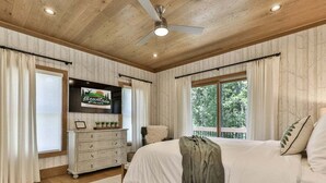 A bedroom with a large bed, a dresser, a ceiling fan, and a window with curtains. - Francis Oaks by Mountain Oasis | Luxury Cabin in Coosawattee River Resort (Ellijay)