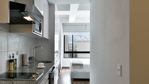 A modern kitchen with a built-in oven, a sink, and a window overlooking a cityscape. - w Stylish Loft w Brilliant Deco in Chapinero (Bogotá)