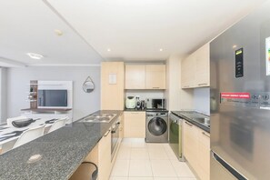 A modern kitchen with a built-in stove, microwave, and washing machine.