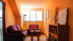 Ein gemütliches Wohnzimmer mit einer Couch, einem Couchtisch und einem Bücherregal.