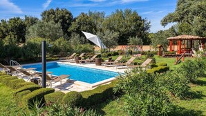 A swimming pool with lounge chairs and a gazebo in a landscaped garden. - Villa Divina in Sisan (Sisan)