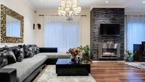 A modern living room with a sectional sofa, a fireplace, and a flat-screen TV. - Modern Cozy Retreat, Park, Mall! (Berwick)