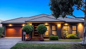 A modern two-story house with a garage, a well-lit front entrance, and a landscaped front yard. - Modern Cozy Retreat, Park, Mall! (Berwick)
