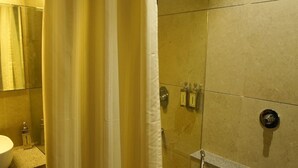 A bathroom with a shower curtain, a toilet, and a sink. - PACHMARHI TIGER  (Pipariya)
