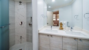 A modern bathroom with a shower, a sink with a mirror, and a toilet. - Sapphire Beach 213 3 Bedroom Apts (St. Lawrence Gap)