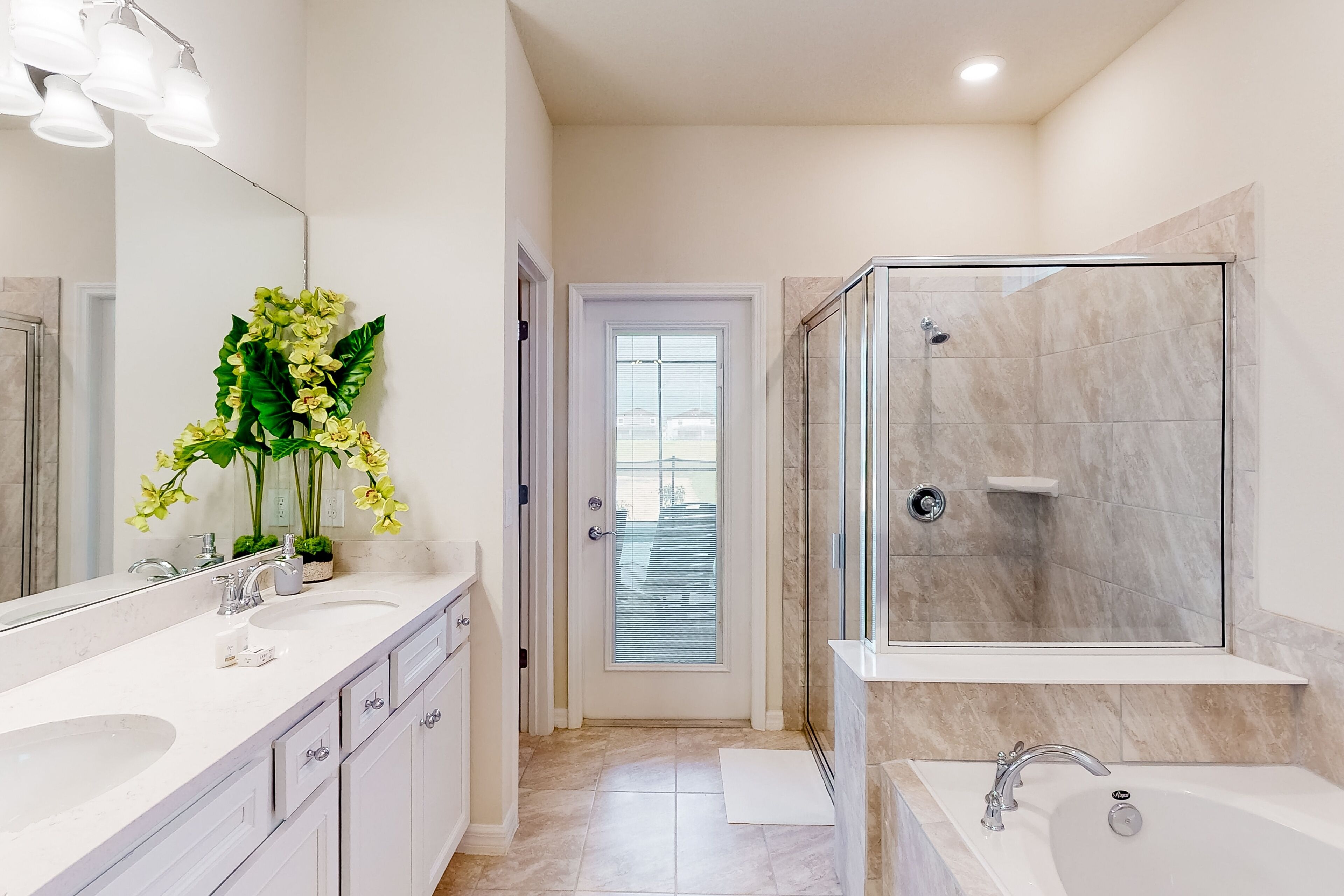 A modern bathroom with a large mirror, a shower, and a bathtub.