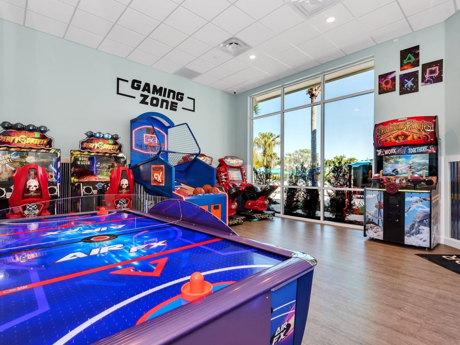 A gaming area with arcade machines, a pool table, and a sign reading "GAMING ZONE".