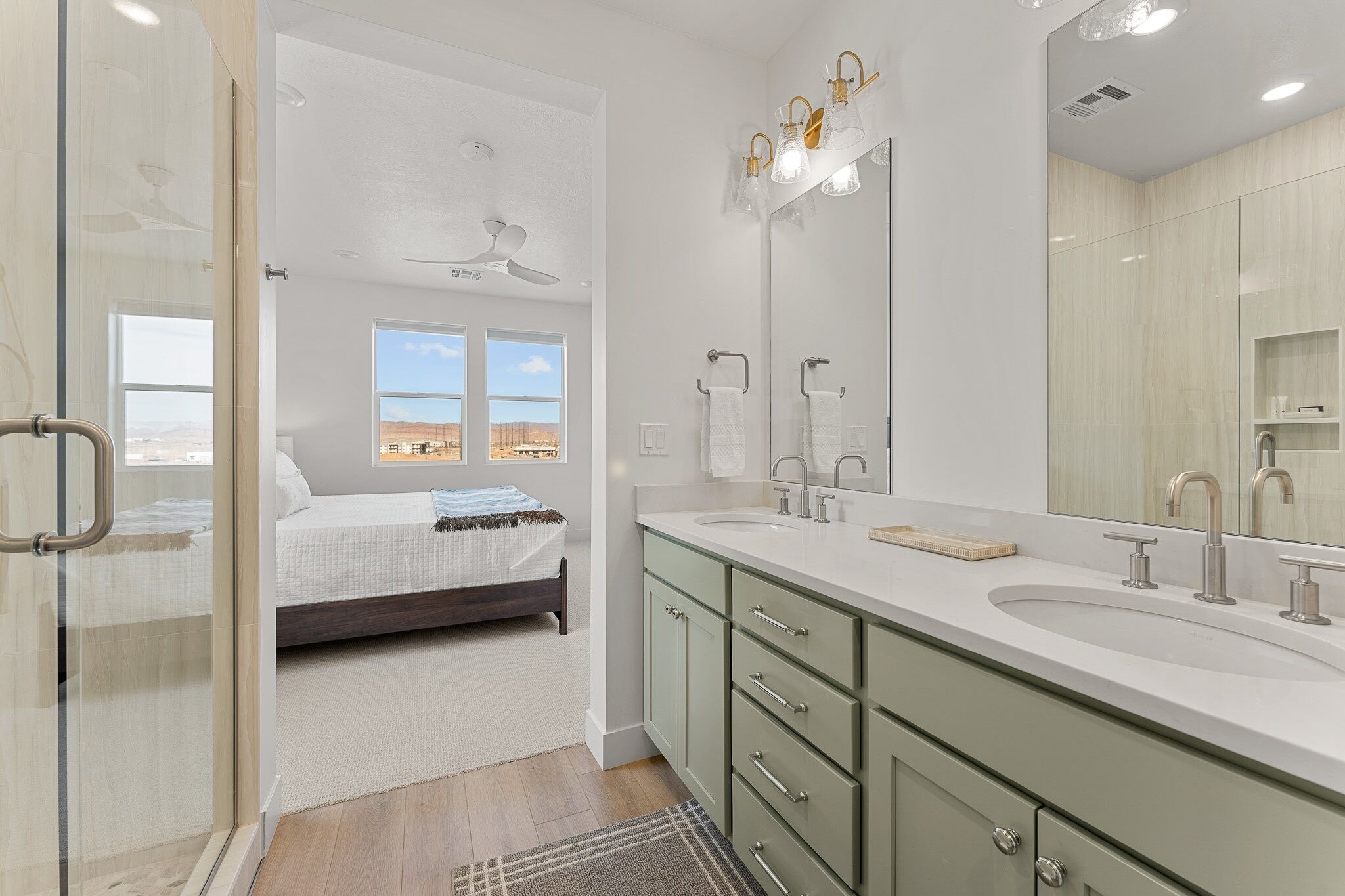 A modern bathroom with a large mirror, dual sinks, and a walk-in shower.