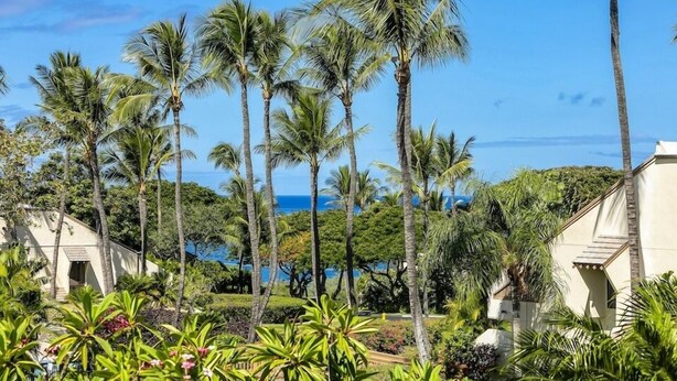 A resort with palm trees, a pool, and a view of the ocean. - Maui Kamaole L107 1 Bedroom Condo (Kihei)