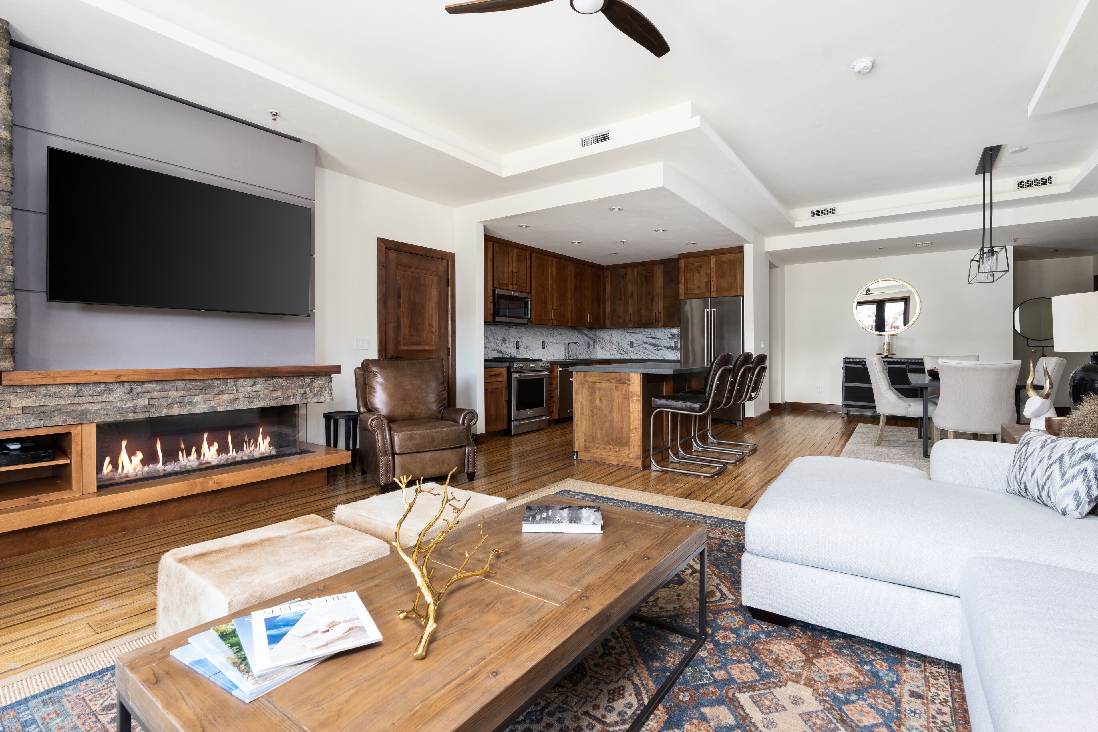 A modern living room with a fireplace, a flat-screen TV, a sofa, and a coffee table.