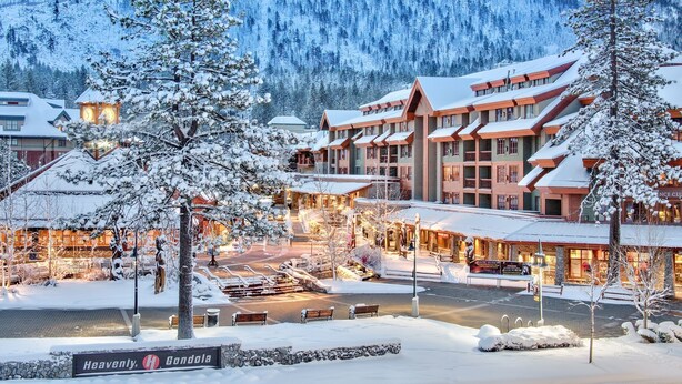 A snow-covered lodge with multiple buildings, a sign reading "Heavenly Gondola," and a mountainous backdrop. - Luxury 4bdr Residence Steps From Heavenly Village 4 Bedroom Condo (South Lake Tahoe)