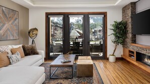 A modern living room with a white sofa, a coffee table, and a fireplace. - Luxury 4bdr Residence Steps From Heavenly Village 4 Bedroom Condo (South Lake Tahoe)