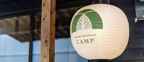 A hanging paper lantern with "Fukuoka Guesthouse CAMP" written on it.