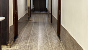 A long, narrow hallway with wooden doors on both sides, leading to a dark room at the end. - Bommarillu Residency (Hyderabad)
