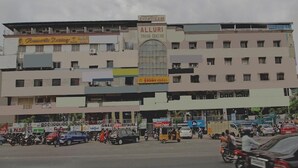 A multi-story building with various shops on the ground floor and a sign for 'ALLURI TRADE CENTRE' on the second floor. - Bommarillu Residency (Hyderabad)