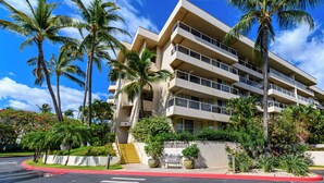 A multi-story hotel with balconies, palm trees, and a clear blue sky. - Blissful 1 Bedroom w/lanai, WiFi, and Cable-#H206 (Kihei)