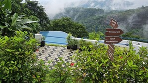 Area piscina con un cartello che indica la strada per un ristorante, una postazione di lavoro e un punto panoramico.