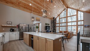 A modern kitchen with wooden cabinets, stainless steel appliances, and a large island.