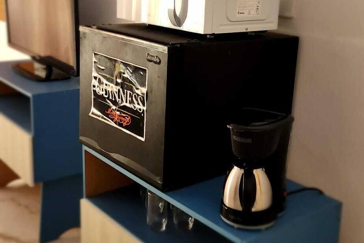 Una cafetera sobre un mueble azul y de madera con la etiqueta que dice "CINNABISS".