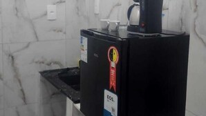 A compact kitchen with a marble backsplash, a coffee maker, and a trash bin. - Hospedagem Rio Lapa  (Rio de Janeiro)