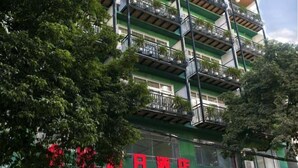 Ein mehrstöckiges Hotel mit Balkonen und Grünpflanzen.