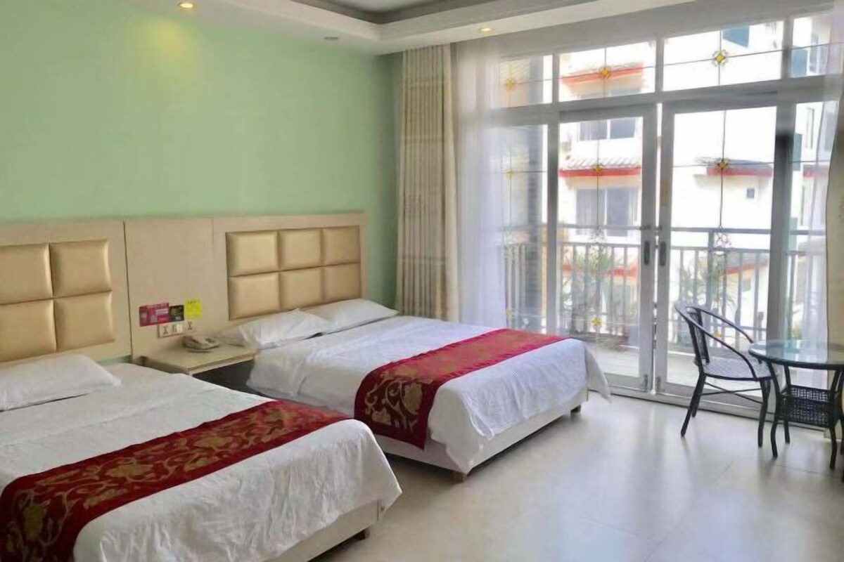 Ein Hotelzimmer mit zwei Betten, einem kleinen Tisch und einem Stuhl.