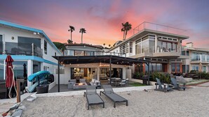 Une propriété située en bord de mer, dotée d’un patio couvert, d’un espace salon extérieur et d’une piscine.