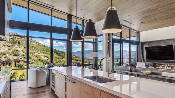A modern kitchen with large windows, a central island, and a built-in oven. - One Snowmass West 601 (Snowmass)