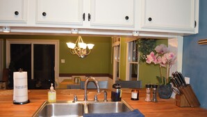 A kitchen with two sinks, a chandelier, and a potted plant. - Cozy Winston-Salem Vacation Cabin (Winston-Salem)