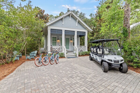 A house with a porch, bicycles, and a golf cart. - Close to Seaside ~ Fully Stocked Kitchen ~ Golf Cart ~ Two Community Pools (Santa Rosa Beach)