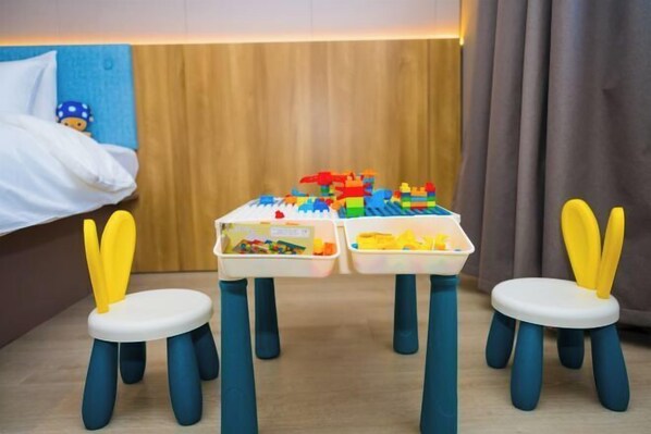 A hotel room with a bed, a wooden headboard, two small tables with toys, and two chairs with yellow handles. - Homeinn · neo (Changzhi Medical College) (Changzhi)
