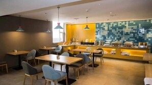 A modern restaurant with wooden tables and chairs, a counter with kitchen appliances, and pendant lighting. - Homeinn · neo (Changzhi Medical College) (Changzhi)